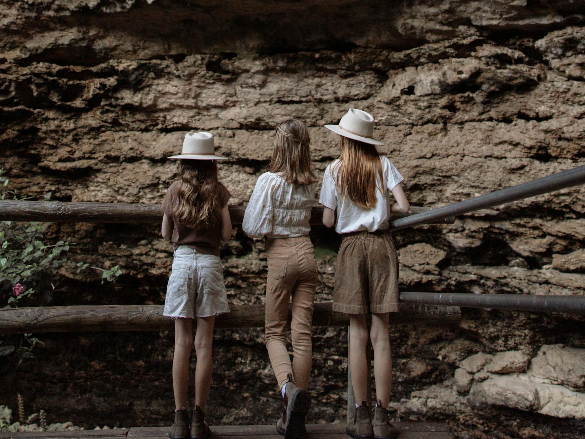 Children standing behind fence looking at rock formations