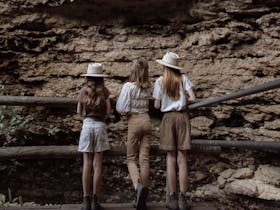 Children standing behind fence looking at rock formations