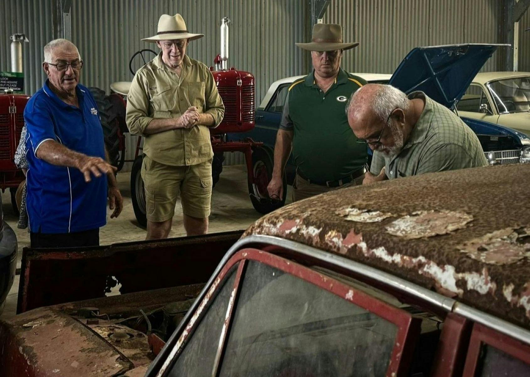 Baz and Ron looking under the hood of a rusty old ford classic car
