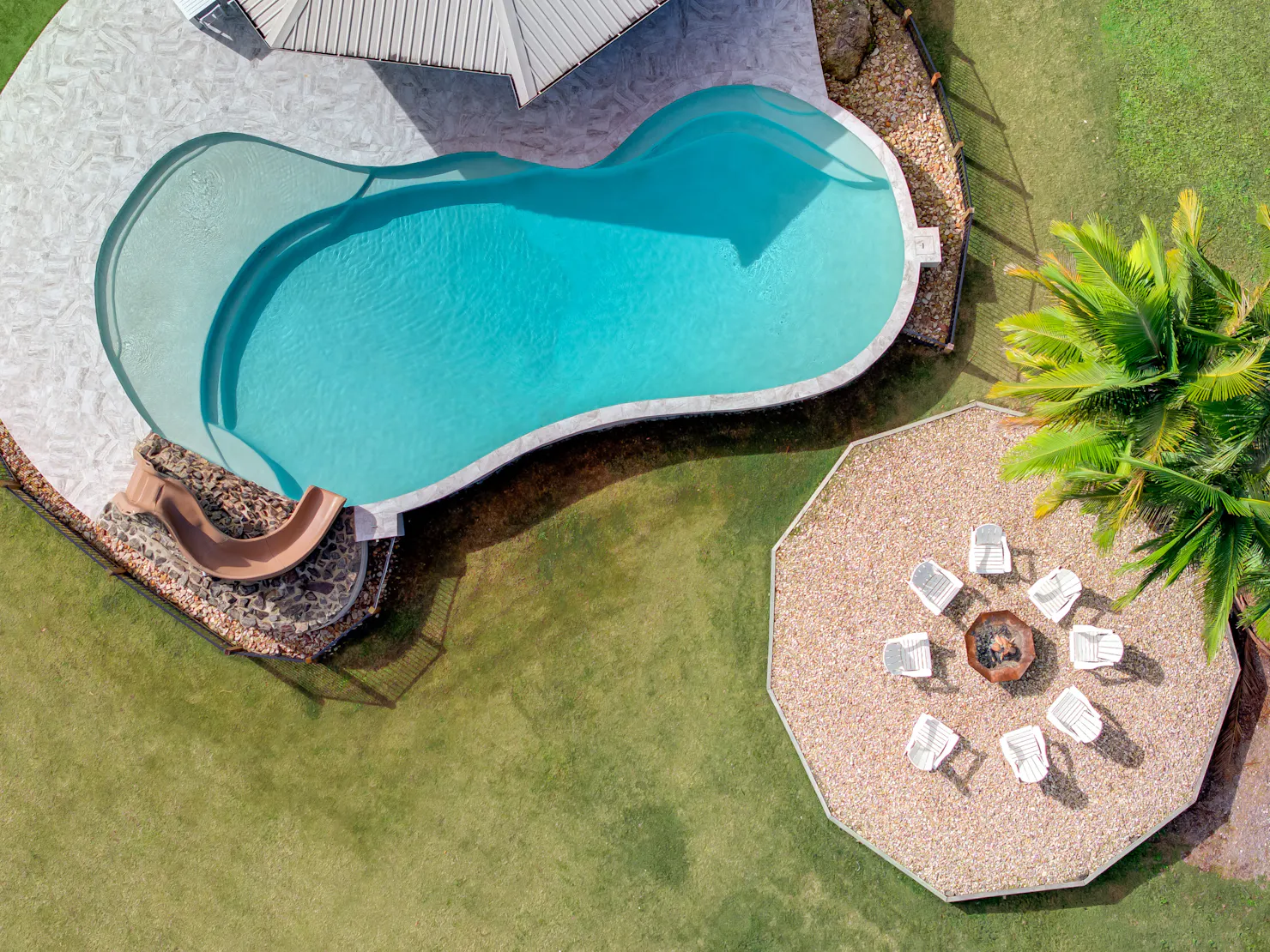 Pool overlooking the stunning rainforest with a slide and fire pit.