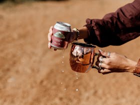 Pouring a Quandong Gin & Tonic premix can into a copper mule