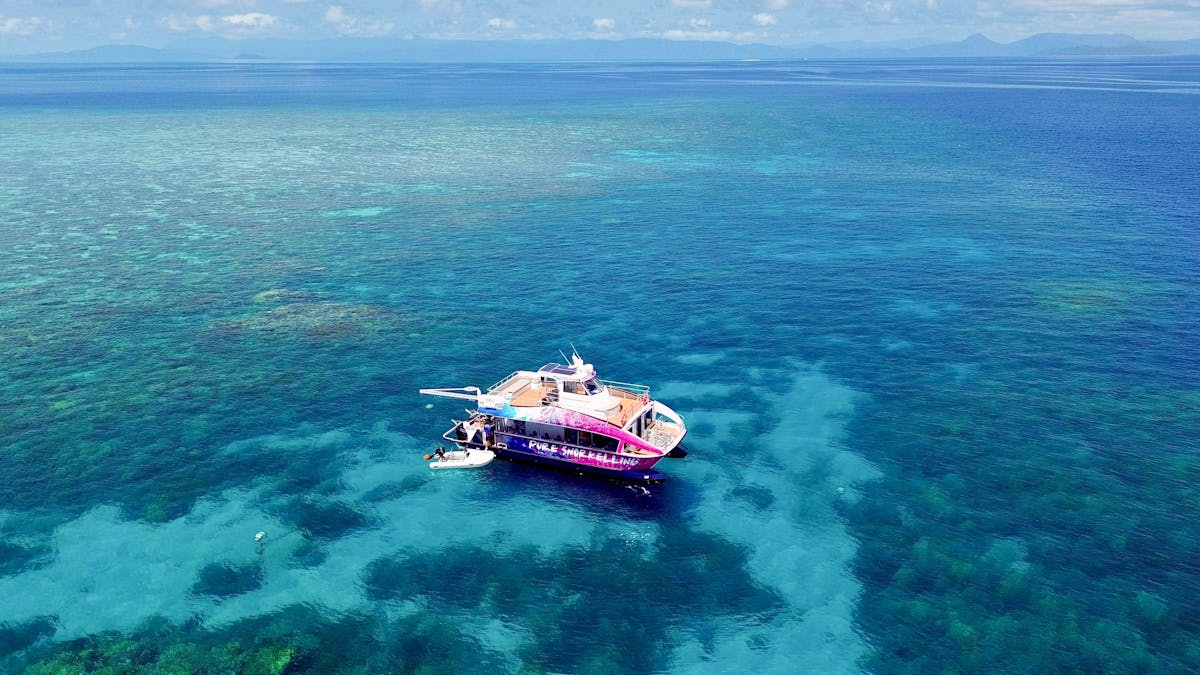 Drone shot of the Pure snorkelling boat at Briggs reef, snorkel site fish bowl