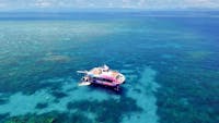 Drone shot of the Pure snorkelling boat at Briggs reef, snorkel site fish bowl