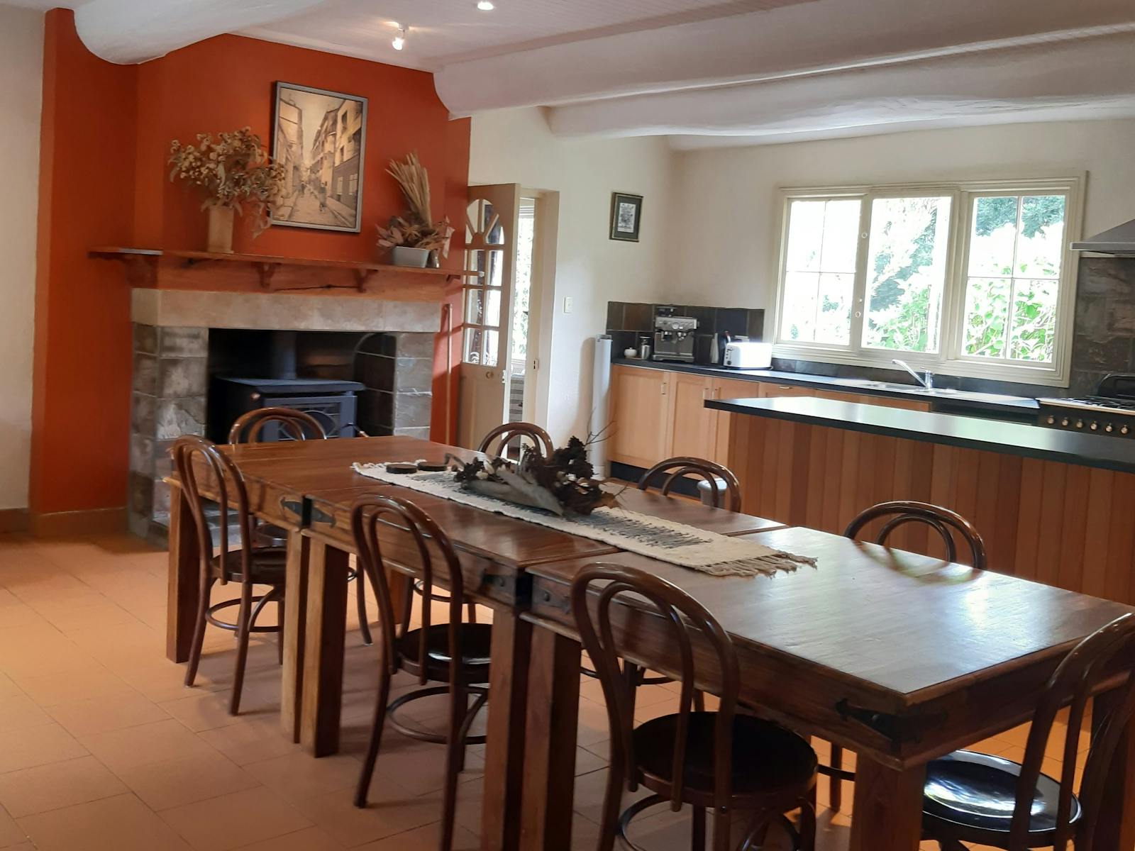 10 seat table next to a fire place and kitchen