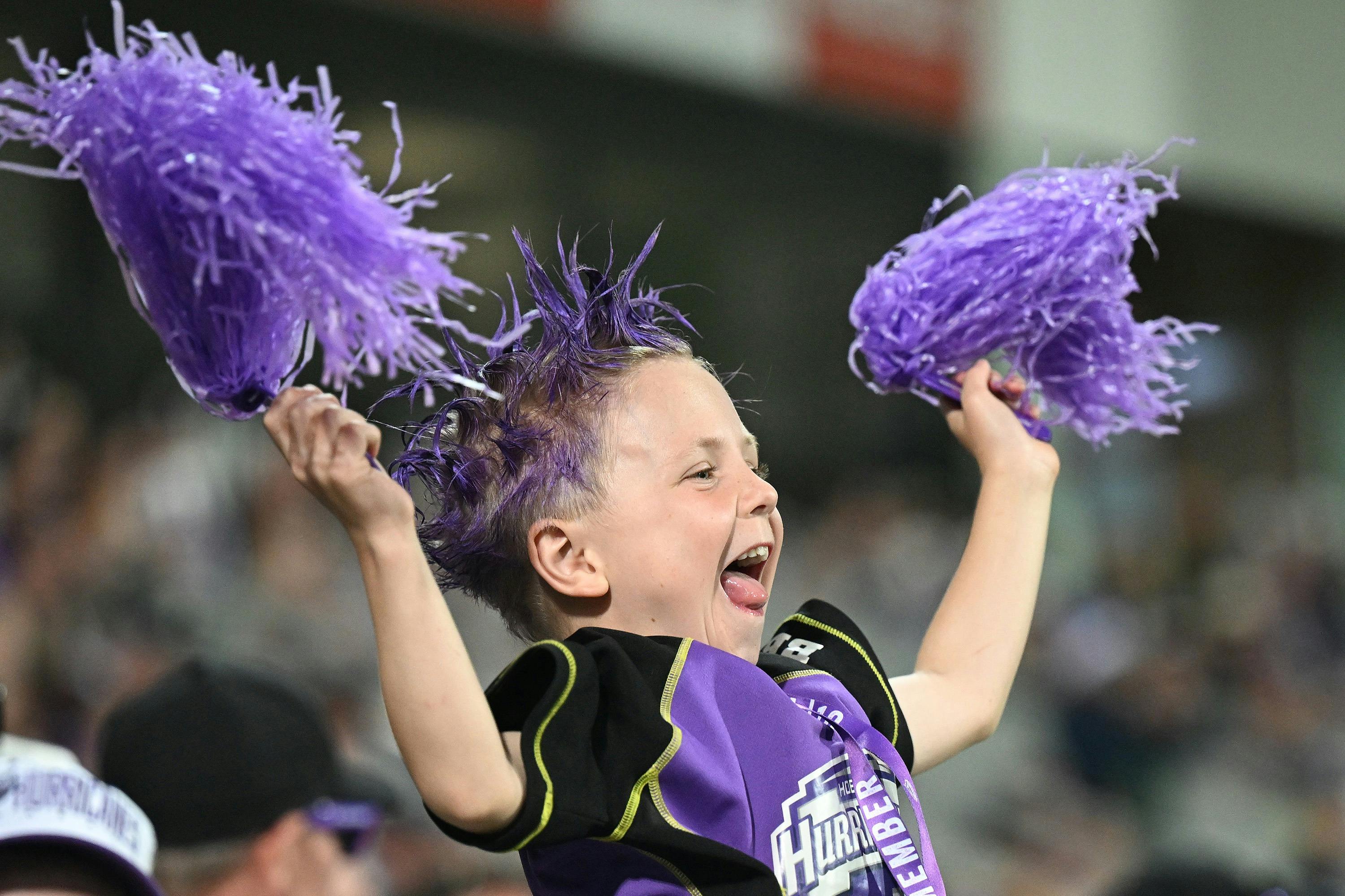 Child waving pom poms in crowd while cheering for Hobart Hurricanes