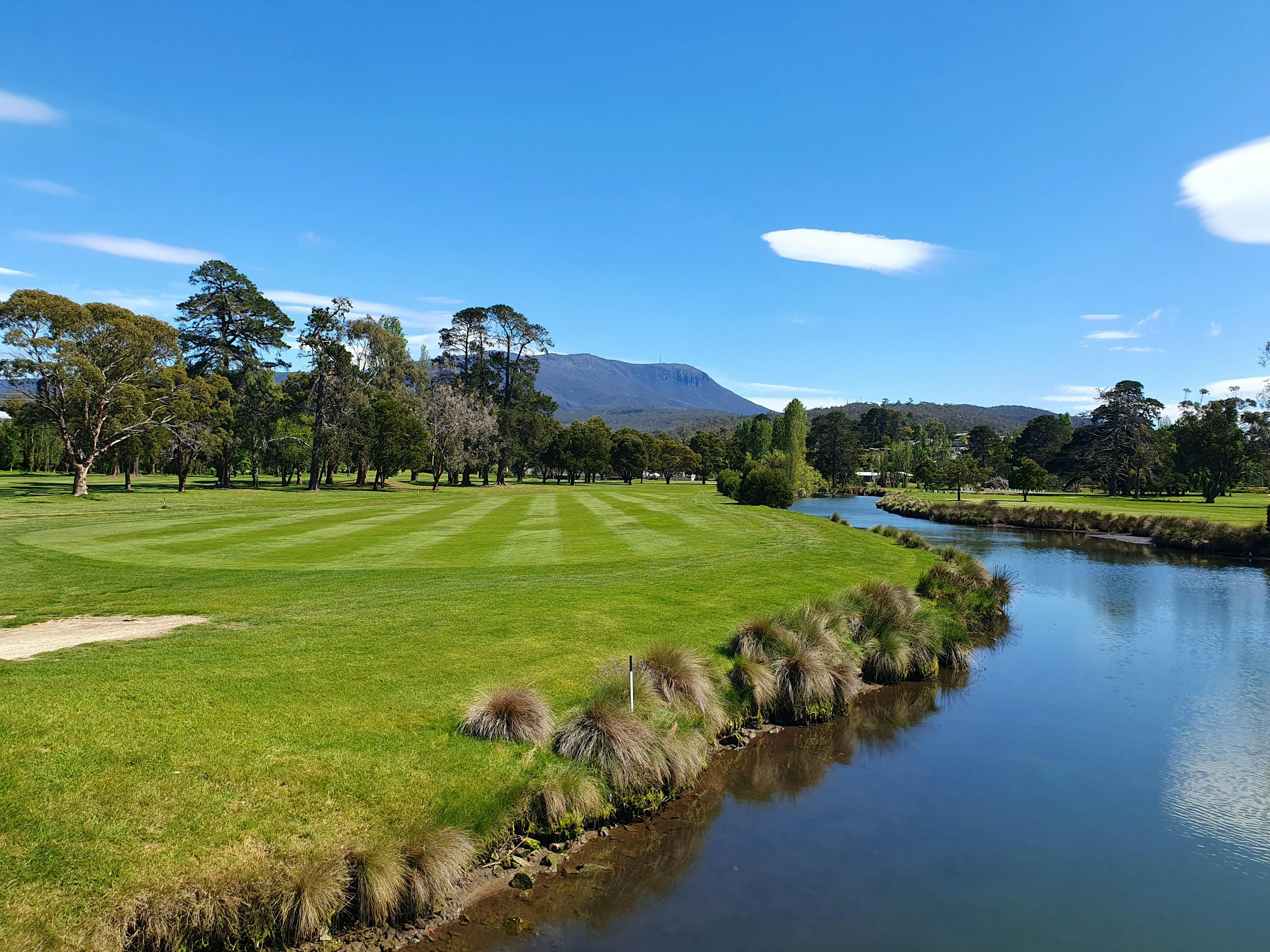 Lush fairway beside river Mount Wellington, Hobart in the background