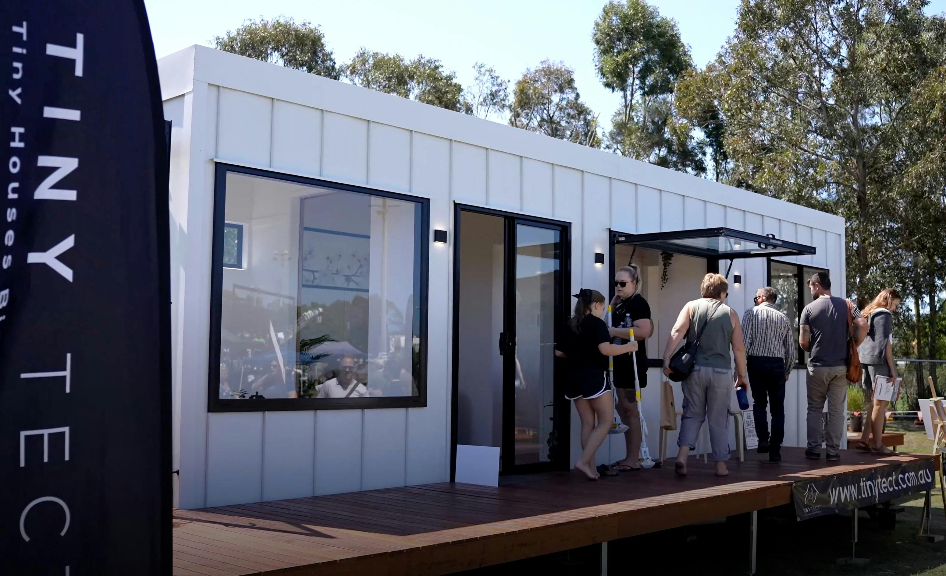 White tiny house by tiny tect with visitors viewing