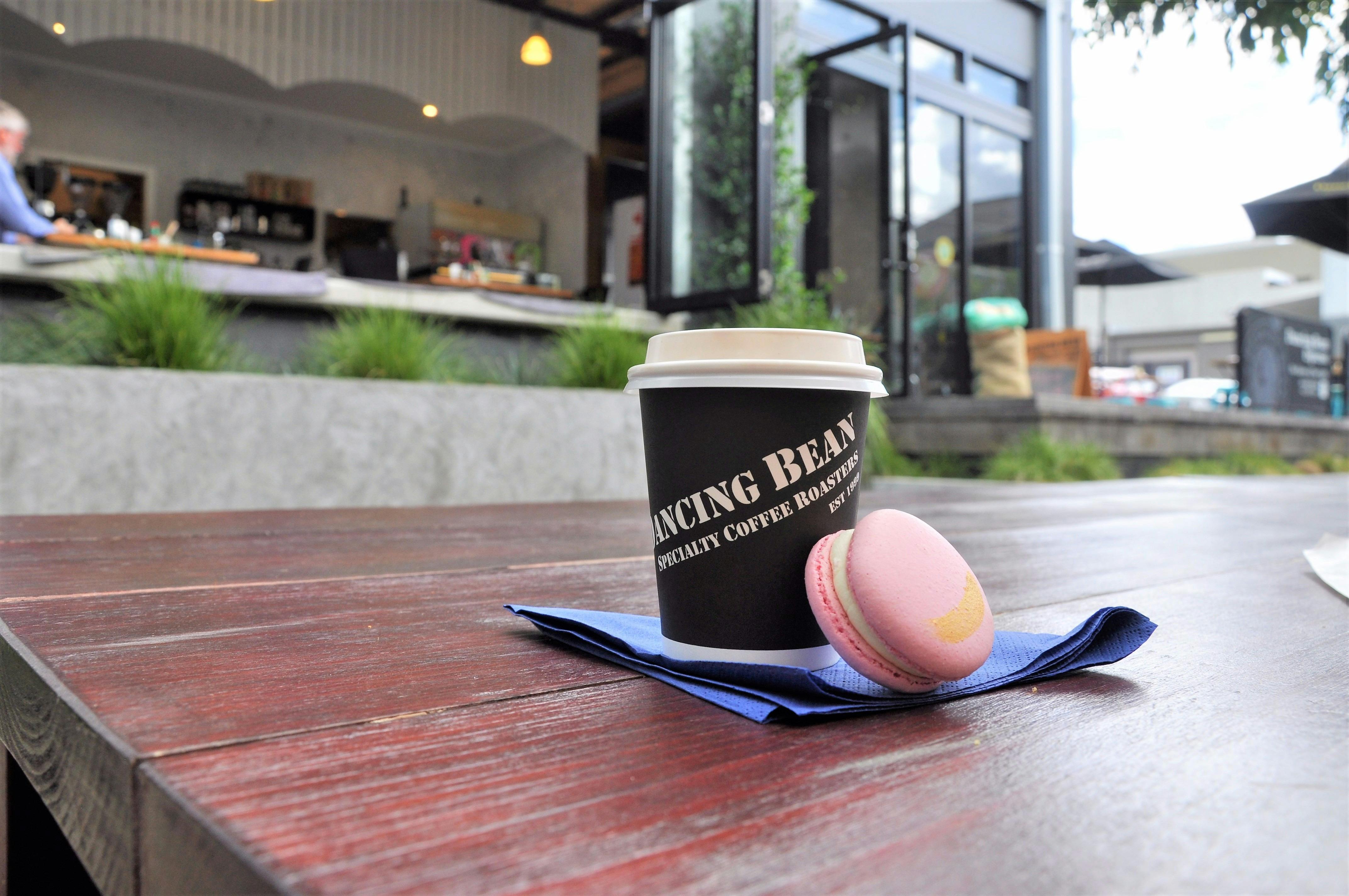 Photo of Coffee and Macaroon with Dancing Bean Espresso Bar in the background