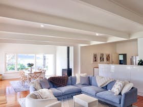 Open plan living and dining area with a modular sofa, dining table and timber floors.