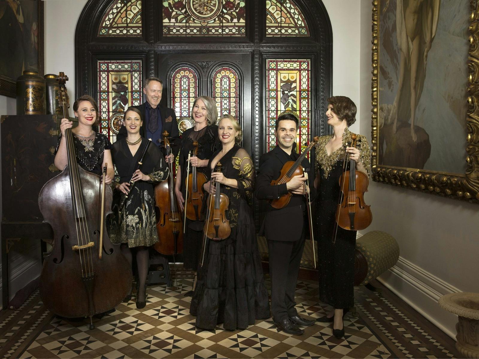 Classical musicians pictured in a grand old house/