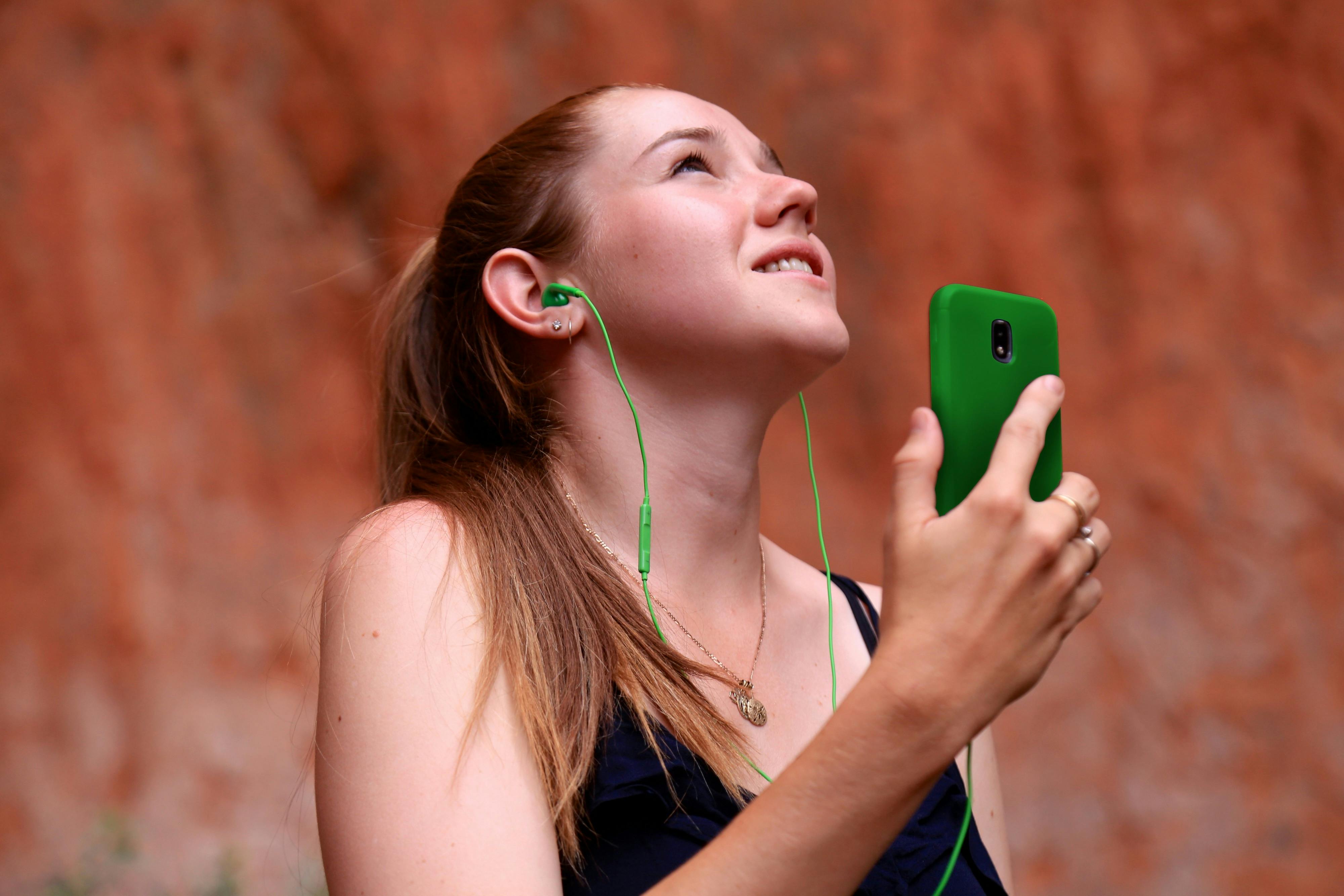 A lady travelling on her own, listens to the Uluru Audio Guide to learn about Uluru.