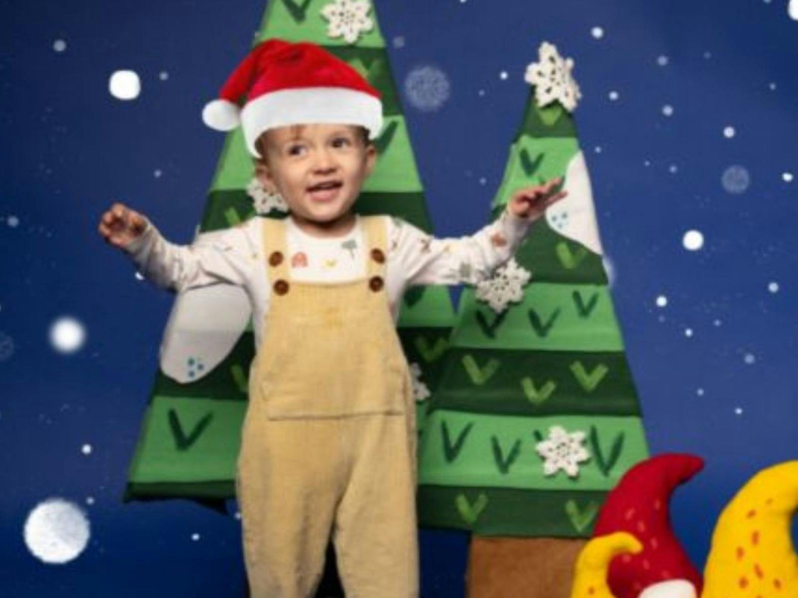 little child in bone overalls with christmas hat on little child in bone overalls with christmas hat on