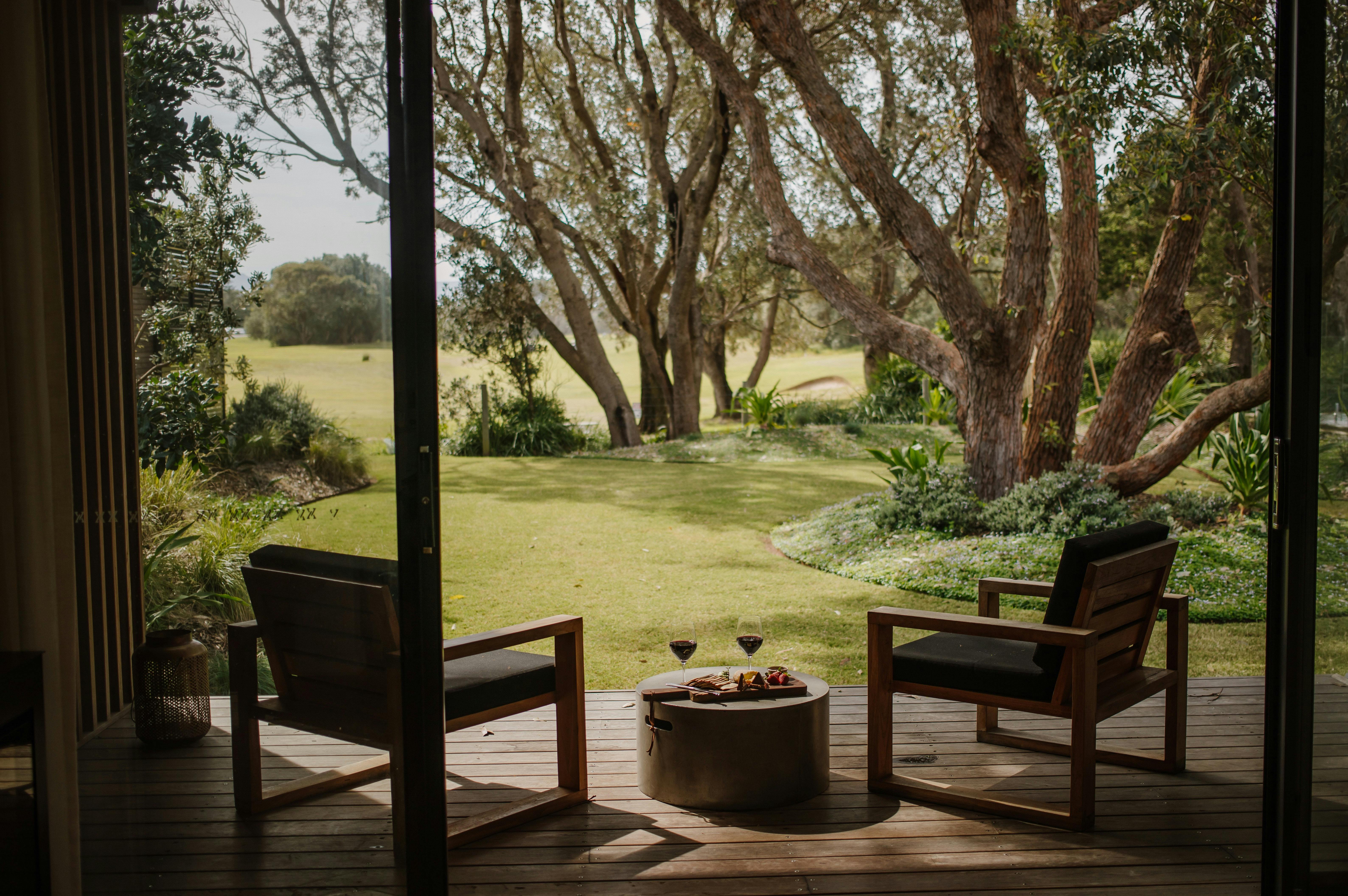 Outdoor seating overlooking the landscaped gardens and native trees at Bangalay Luxury Villas in Sho
