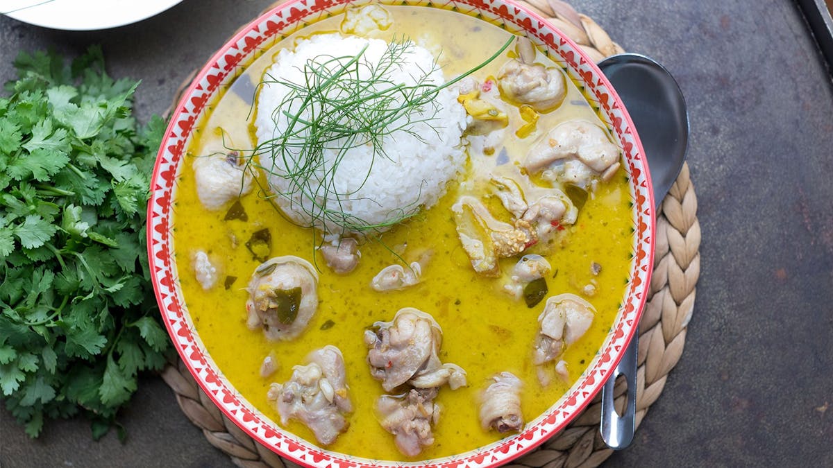 A bowl of green chicken curry with rice