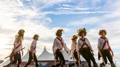 6 Morris Dancers perform in Traditional Costume with a big-top tent in the background