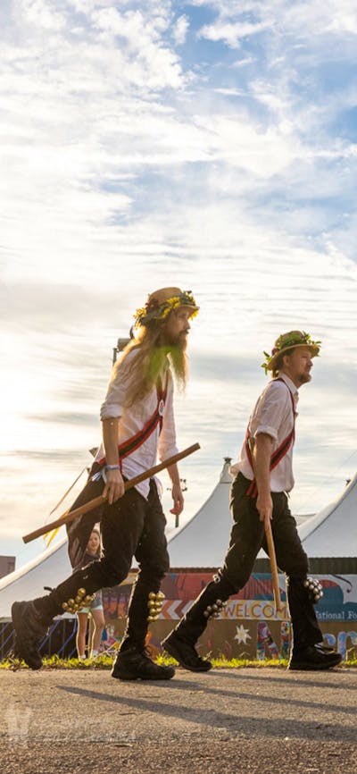 6 Morris Dancers perform in Traditional Costume with a big-top tent in the background