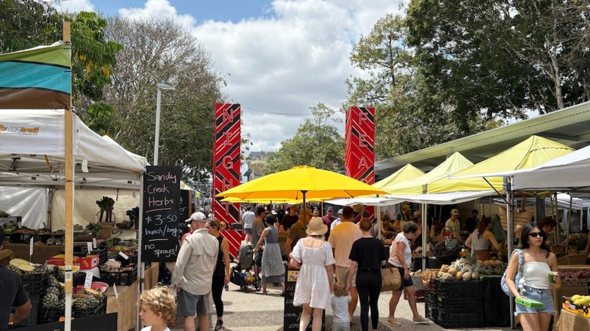 Entrance to the Jan Powers Farmers Markets with many bustling people and stalls
