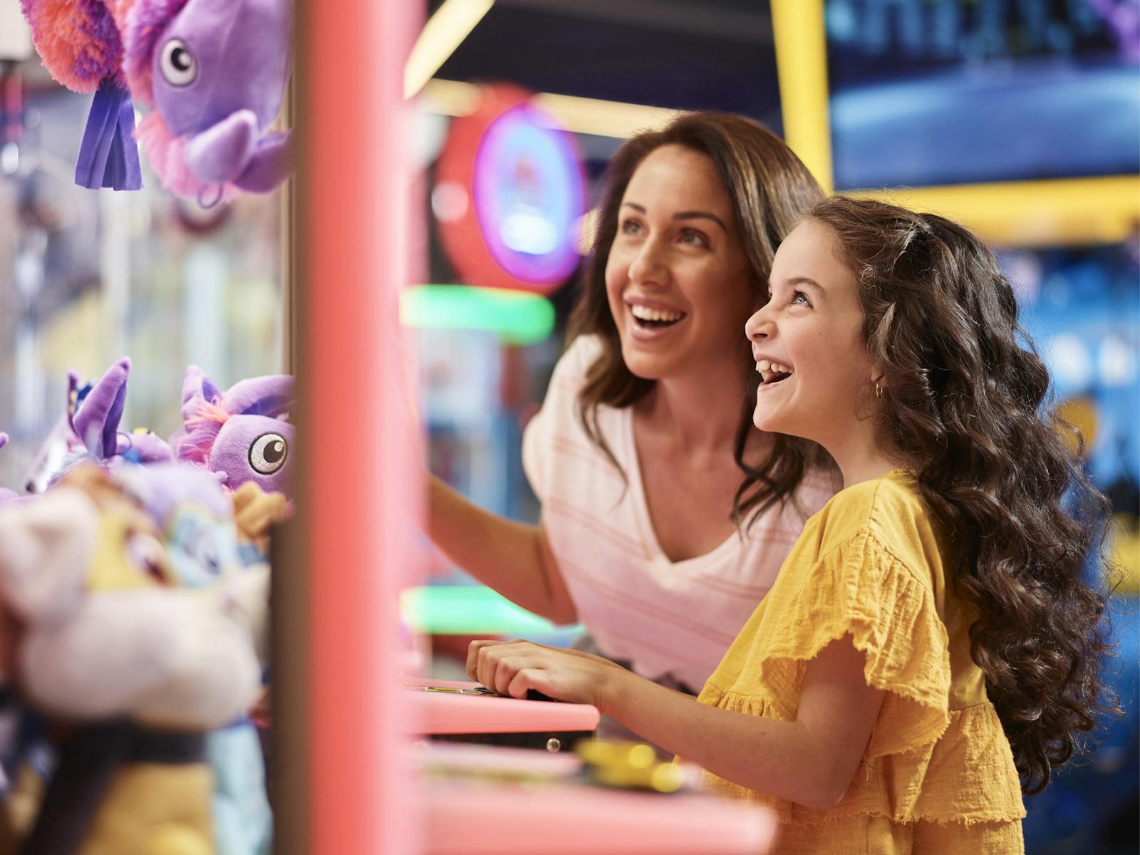 Mum and daughter trying their luck at winning a soft toy by playing a skilltester