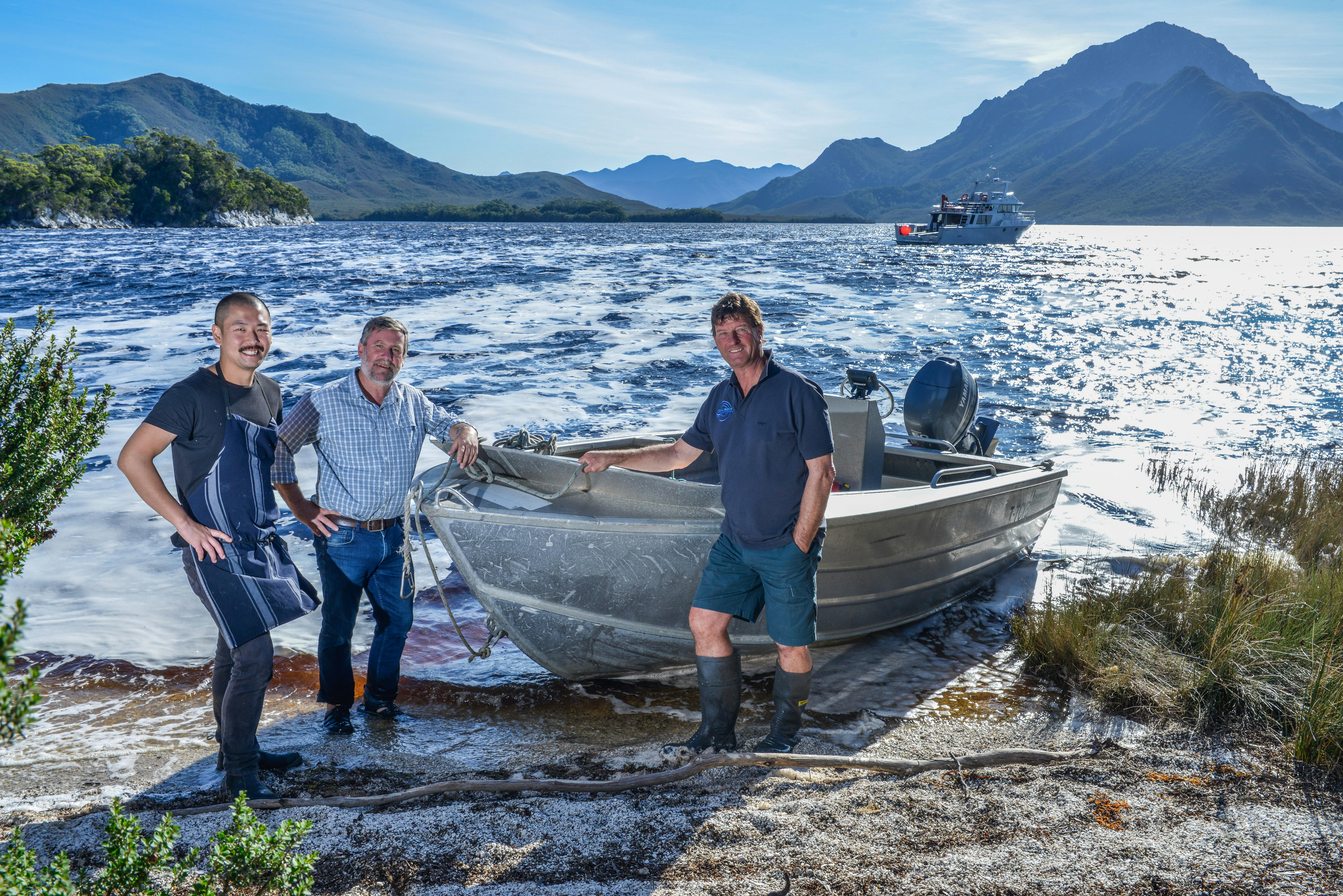 3 crew standing with the tender vessel on the shores of port davey.