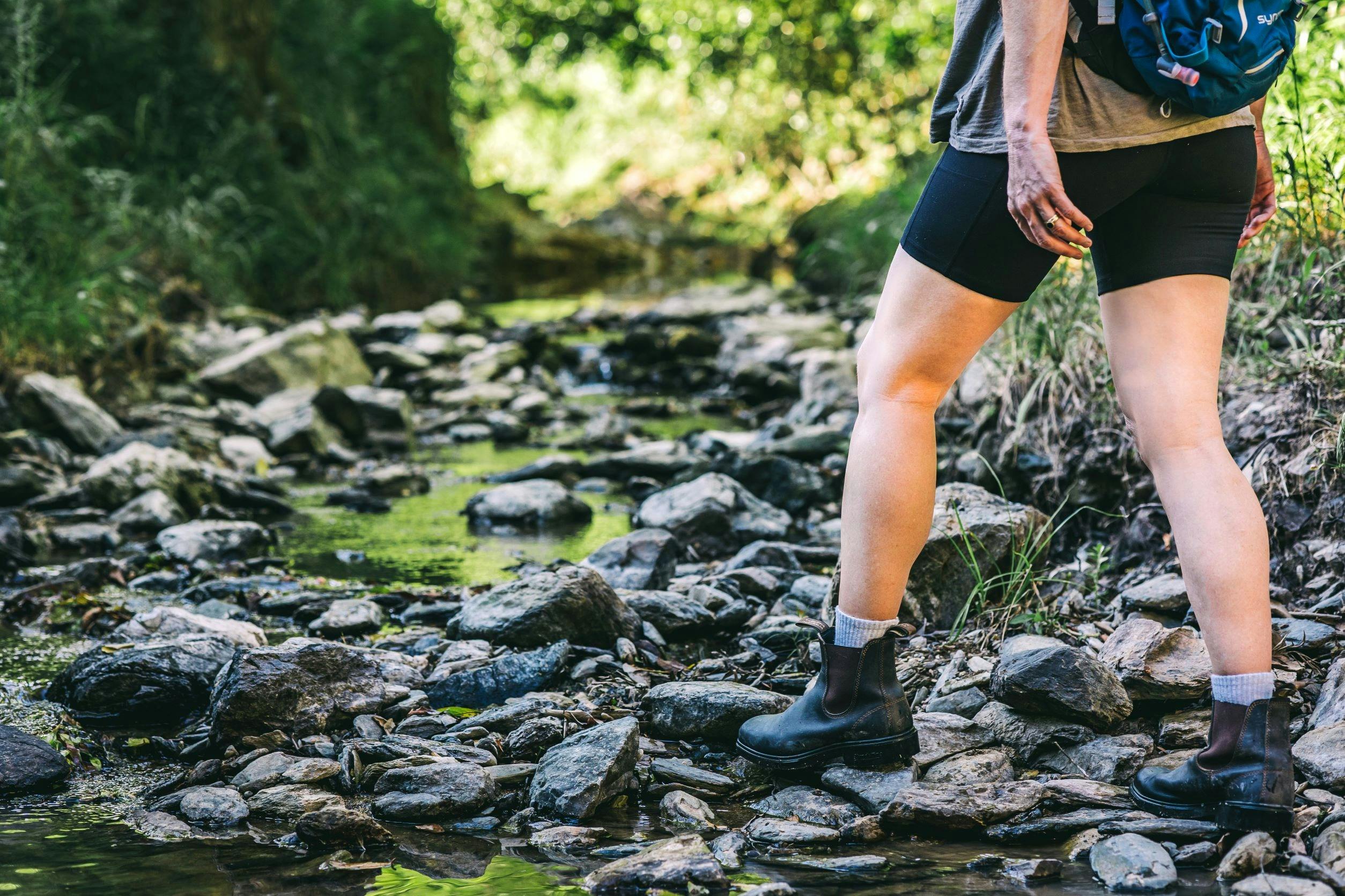 A woman walking through the forest, focused on her feet
