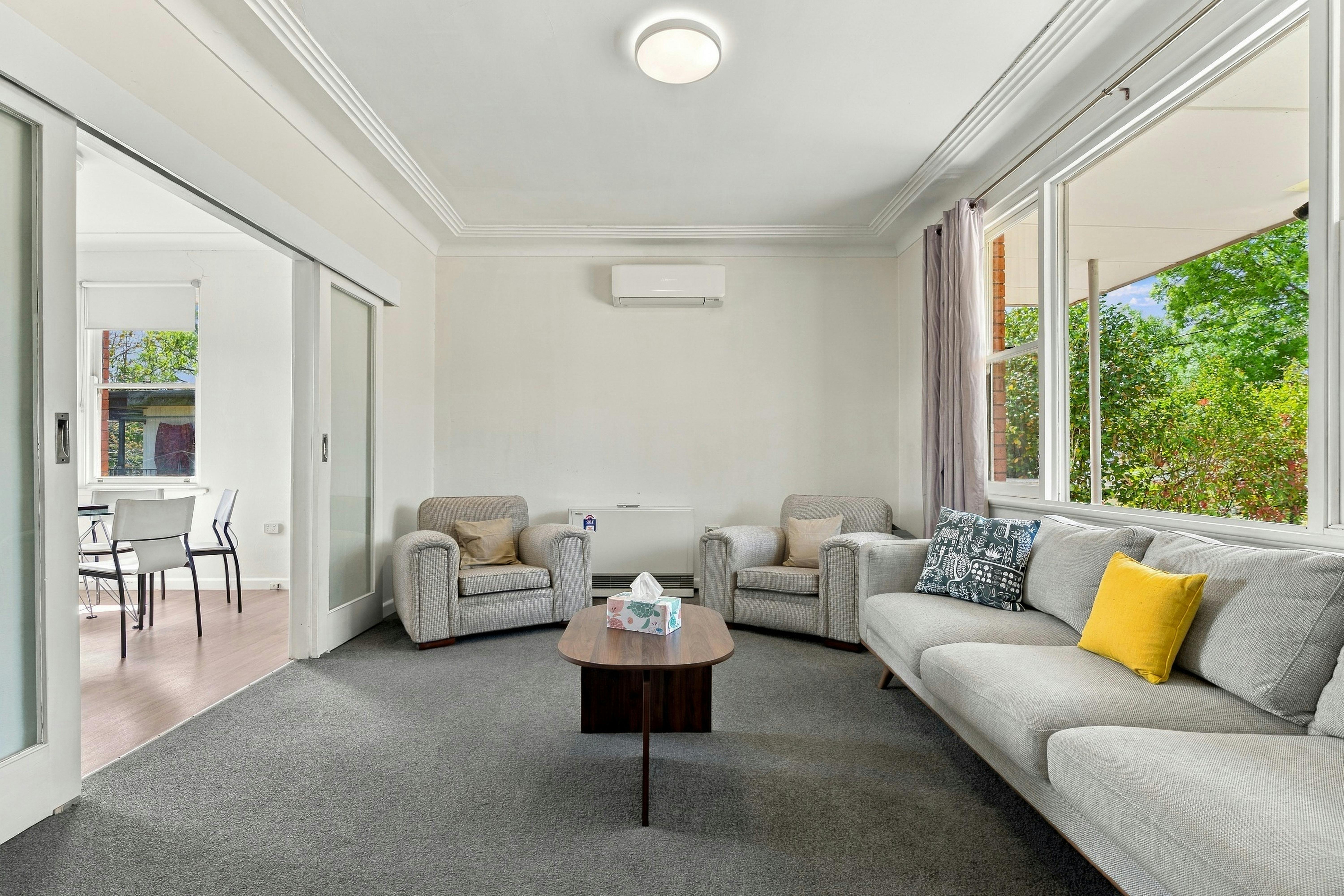 Lounge room with 2 grey armchairs and a grey couch
