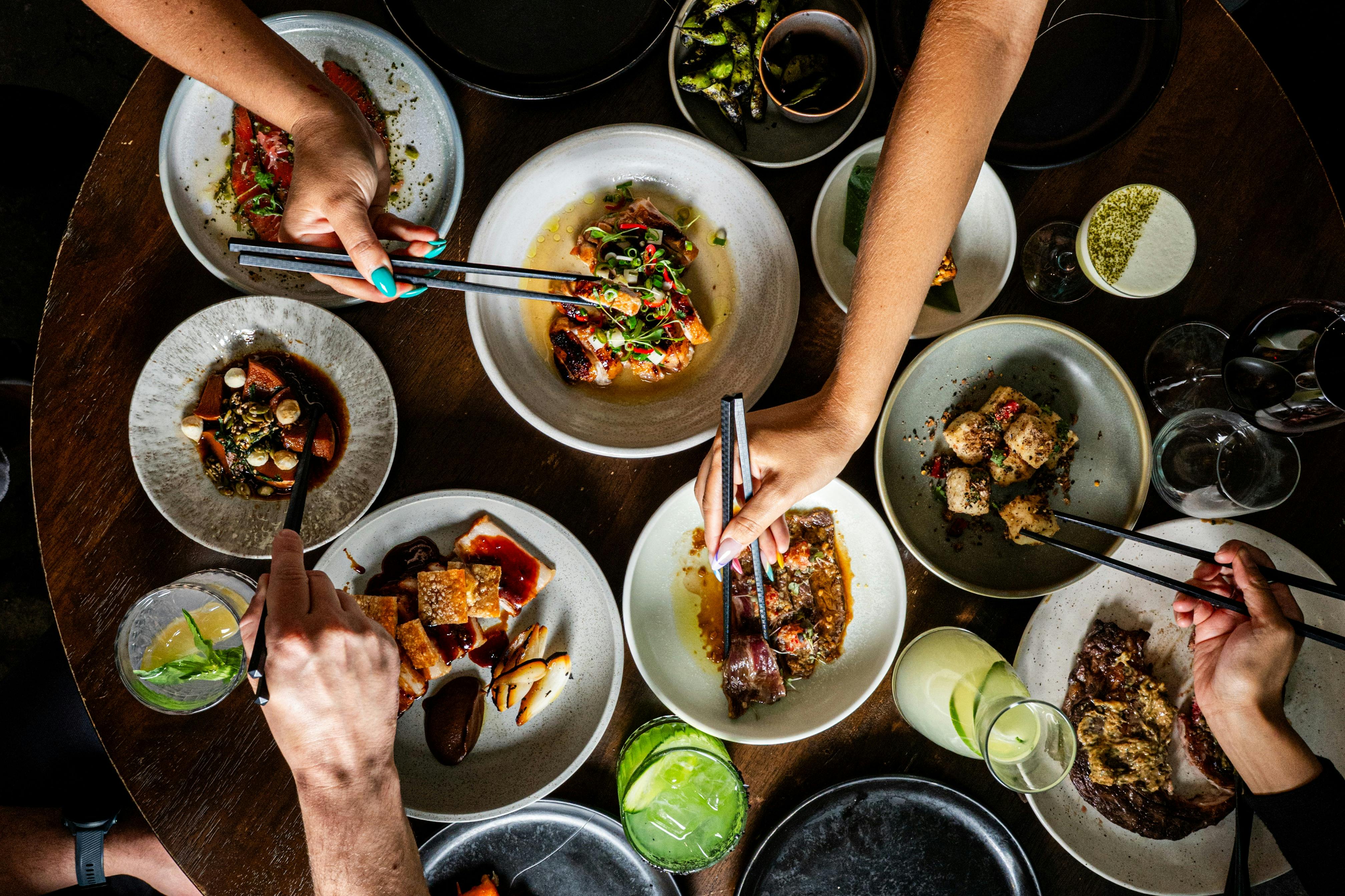 Multiple hands digging into plates