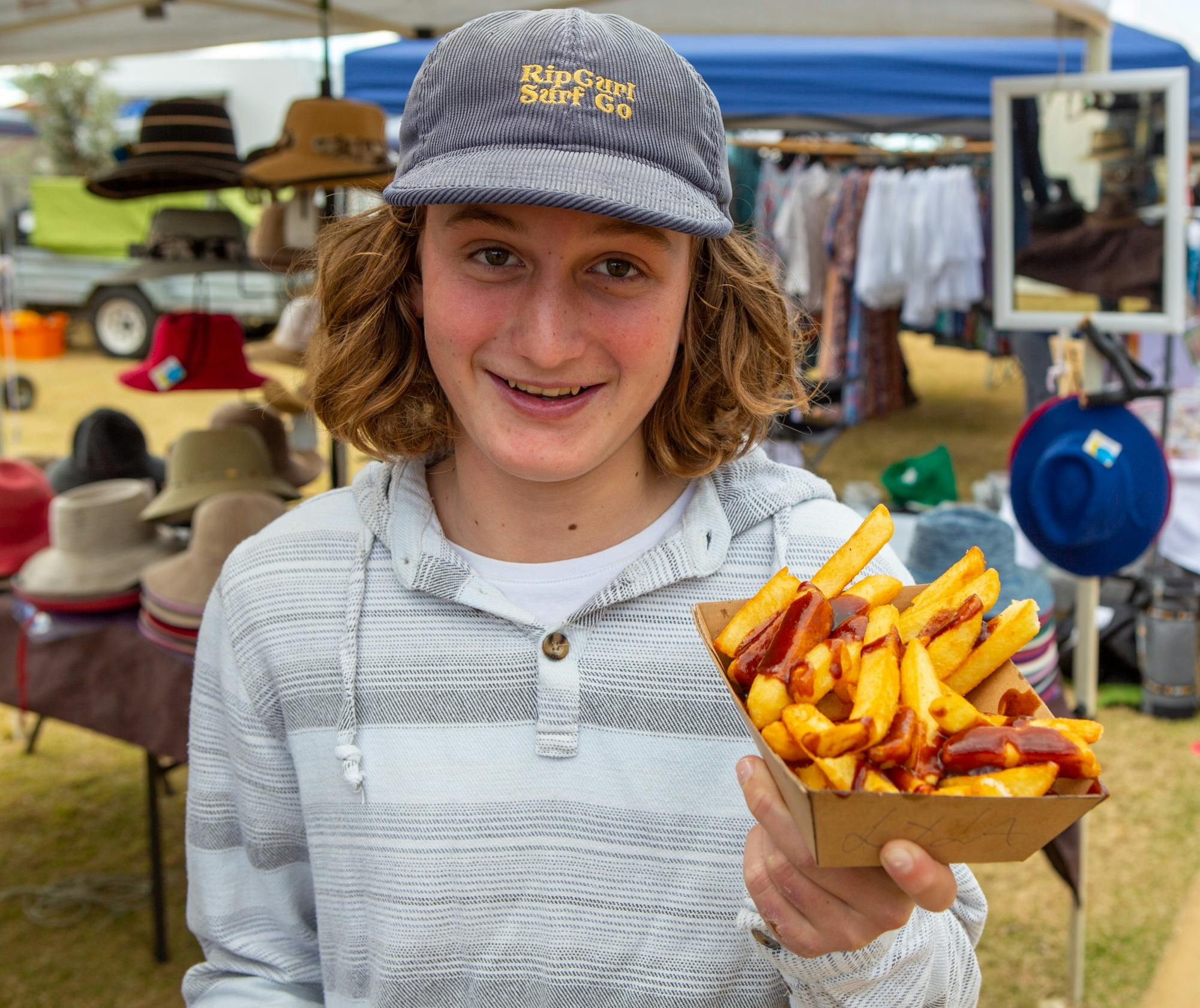Young boy enjoying some hot chips at Harbourside Markets
