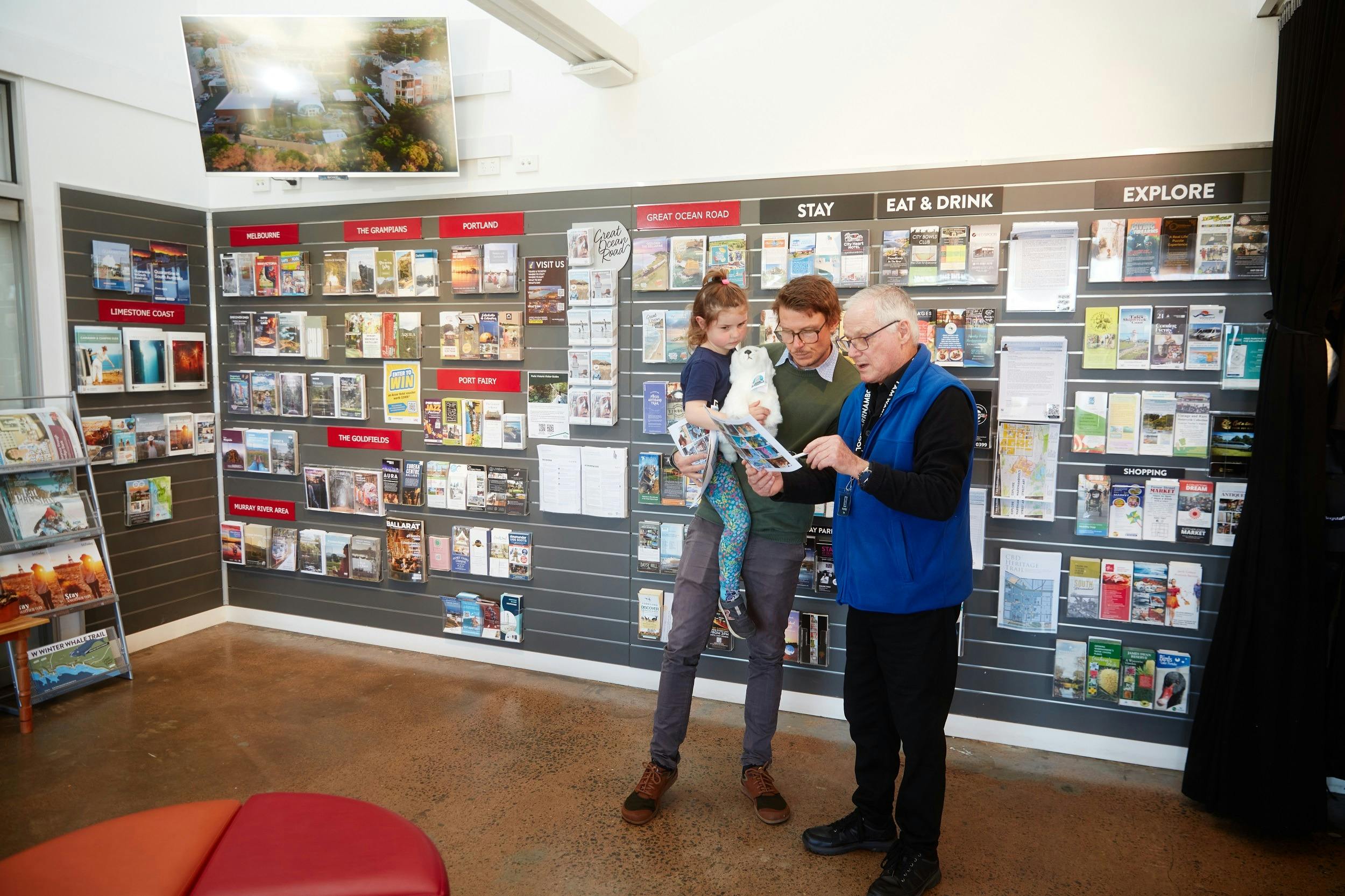Staff member assisting a man and child with information