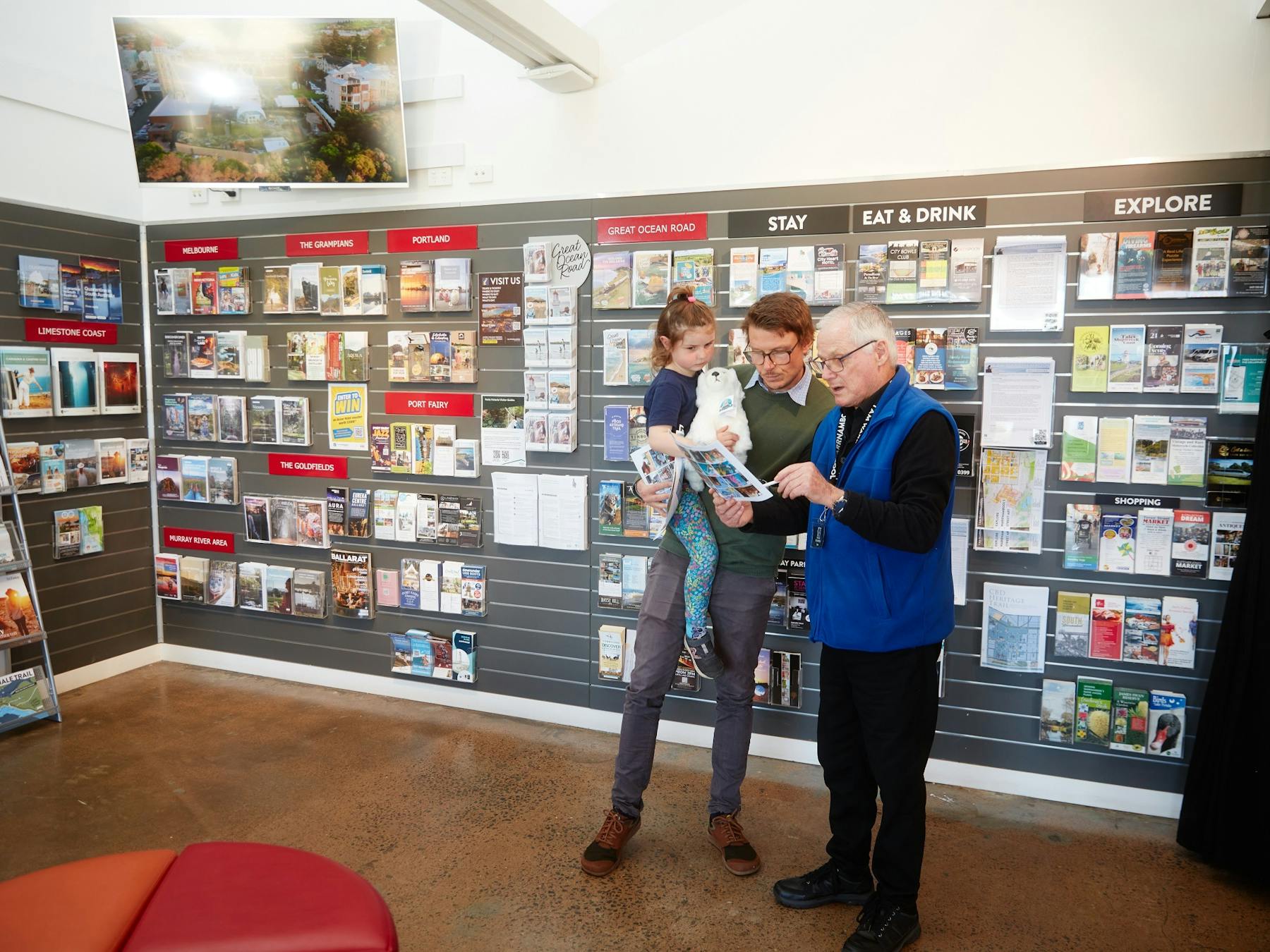 Staff member assisting a man and child with information
