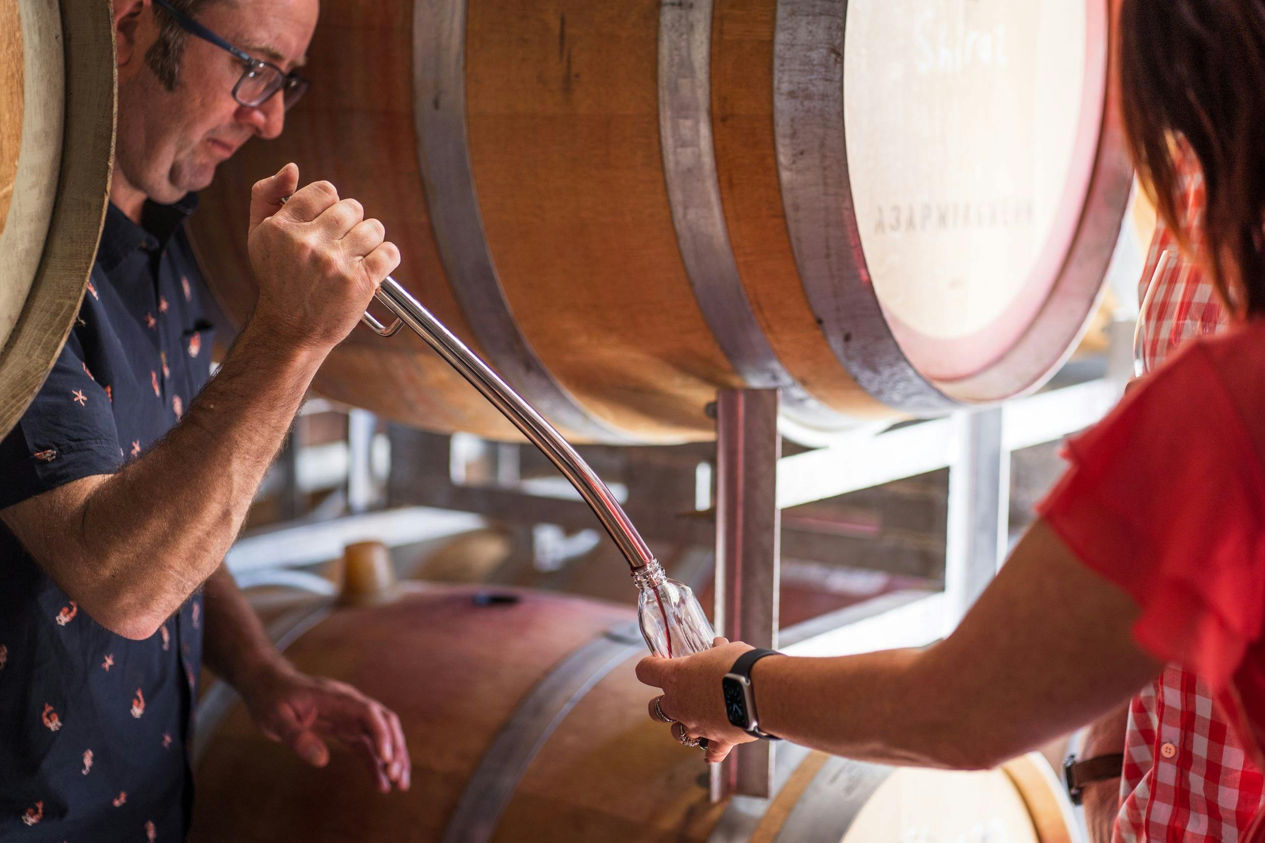 Winemaker Derek filling a sample bottle with red wine