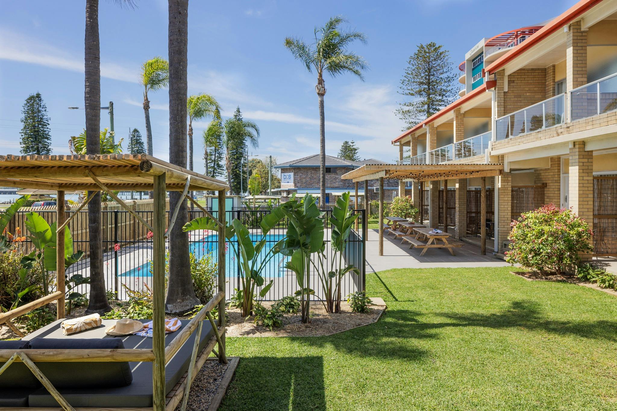 サウス パシフィック パームス モーテル 緑豊かな芝生とプールエリア