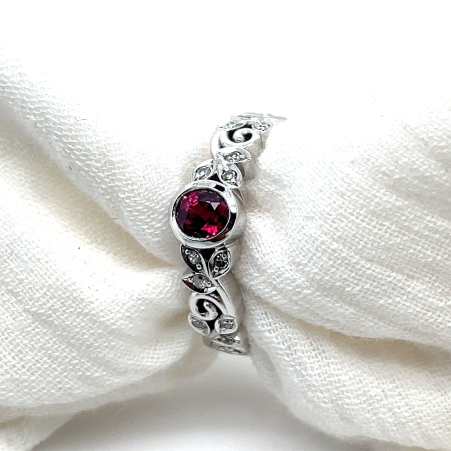 Ruby and diamond white gold ring with intricate leaf pattern band