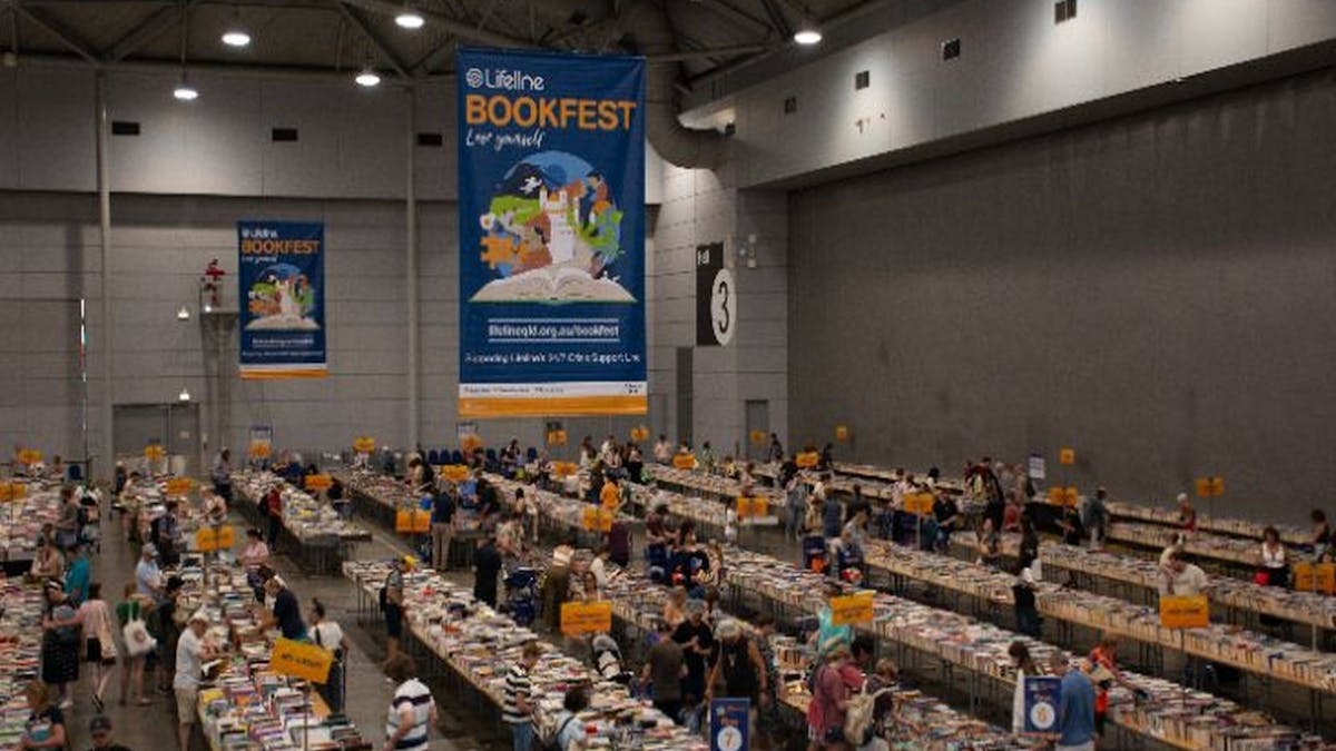 Looking down on rows and rows of long tables of books Looking down on rows and rows of long tables of books