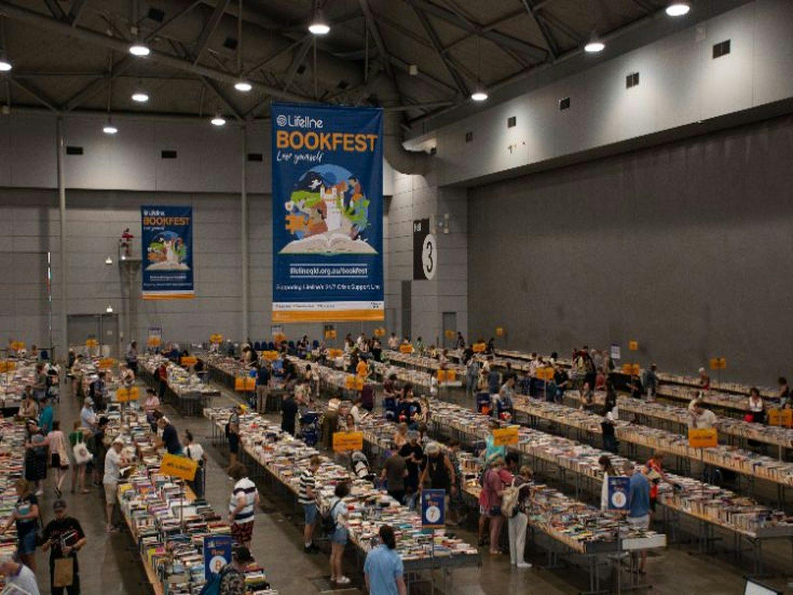 Looking down on rows and rows of long tables of books Looking down on rows and rows of long tables of books
