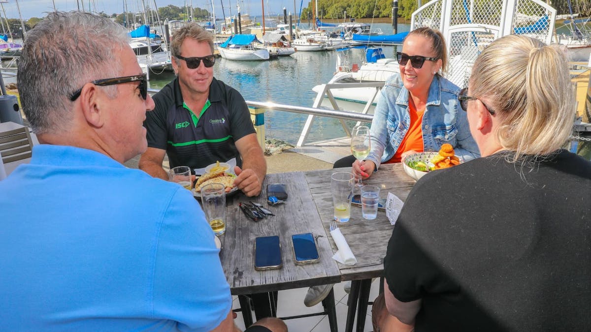 Guests enjoying drinks and lunch sitting by the Marina