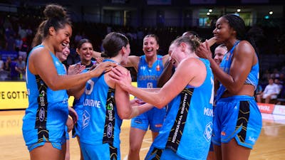 UC Capitals players celebrate in a circle after winning a game.