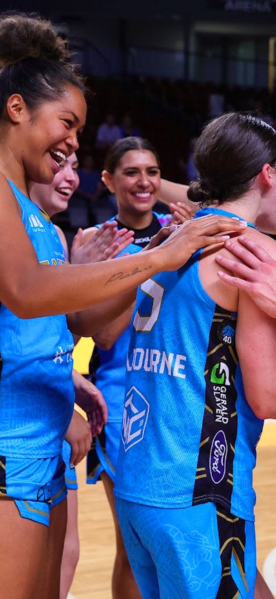 UC Capitals players celebrate in a circle after winning a game.