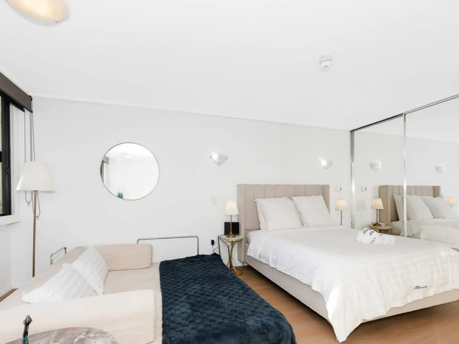 Modern studio apartment featuring queen bed, sofa, and open-plan layout