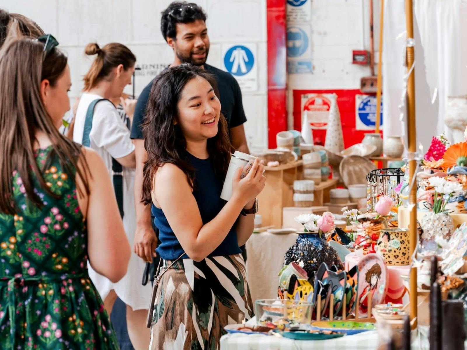 A women shopping at the market and smiling which holding a piece