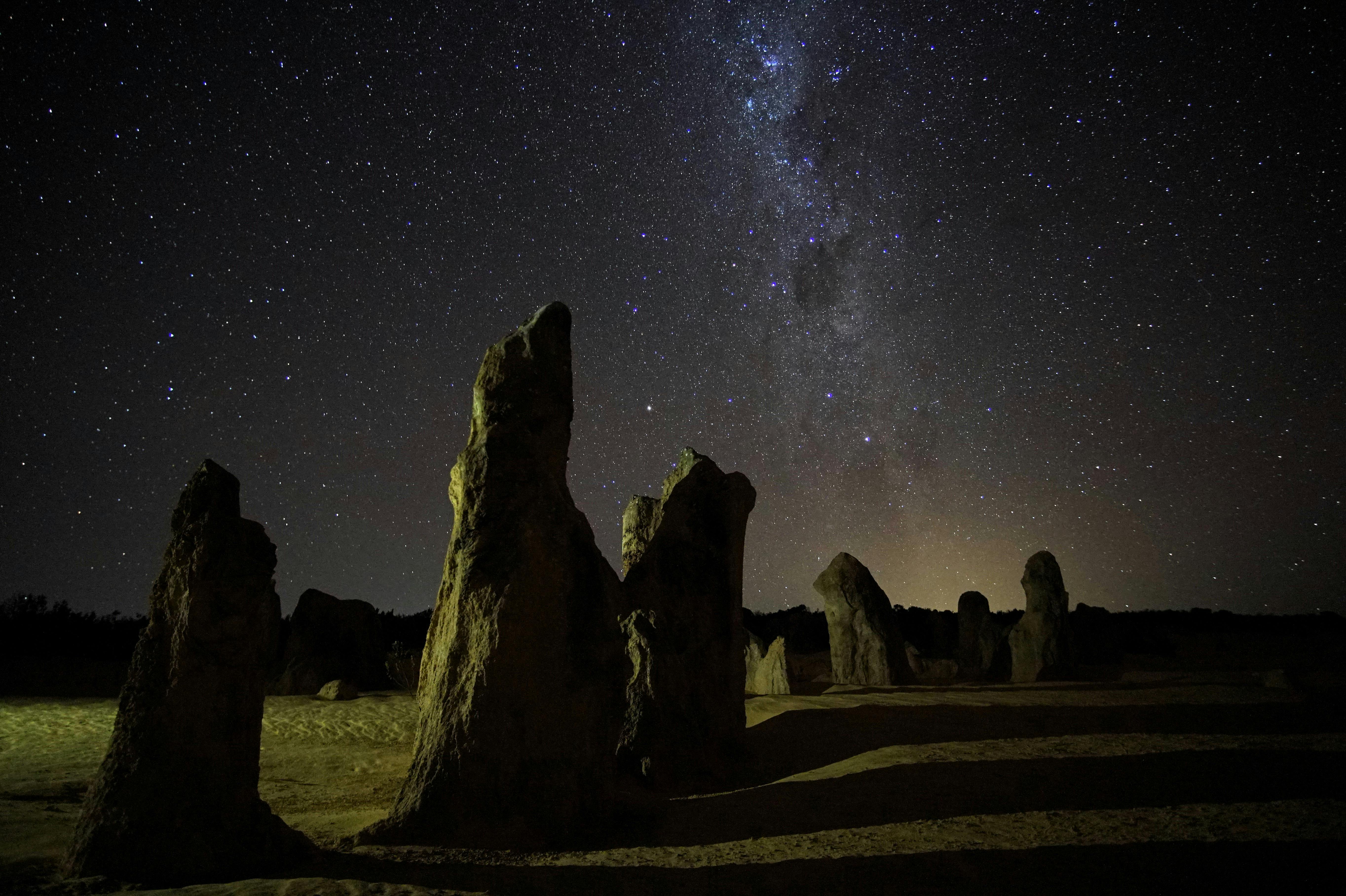 Photo of the otherwordly Pinnacles, a series of natural sandsand monoliths at night