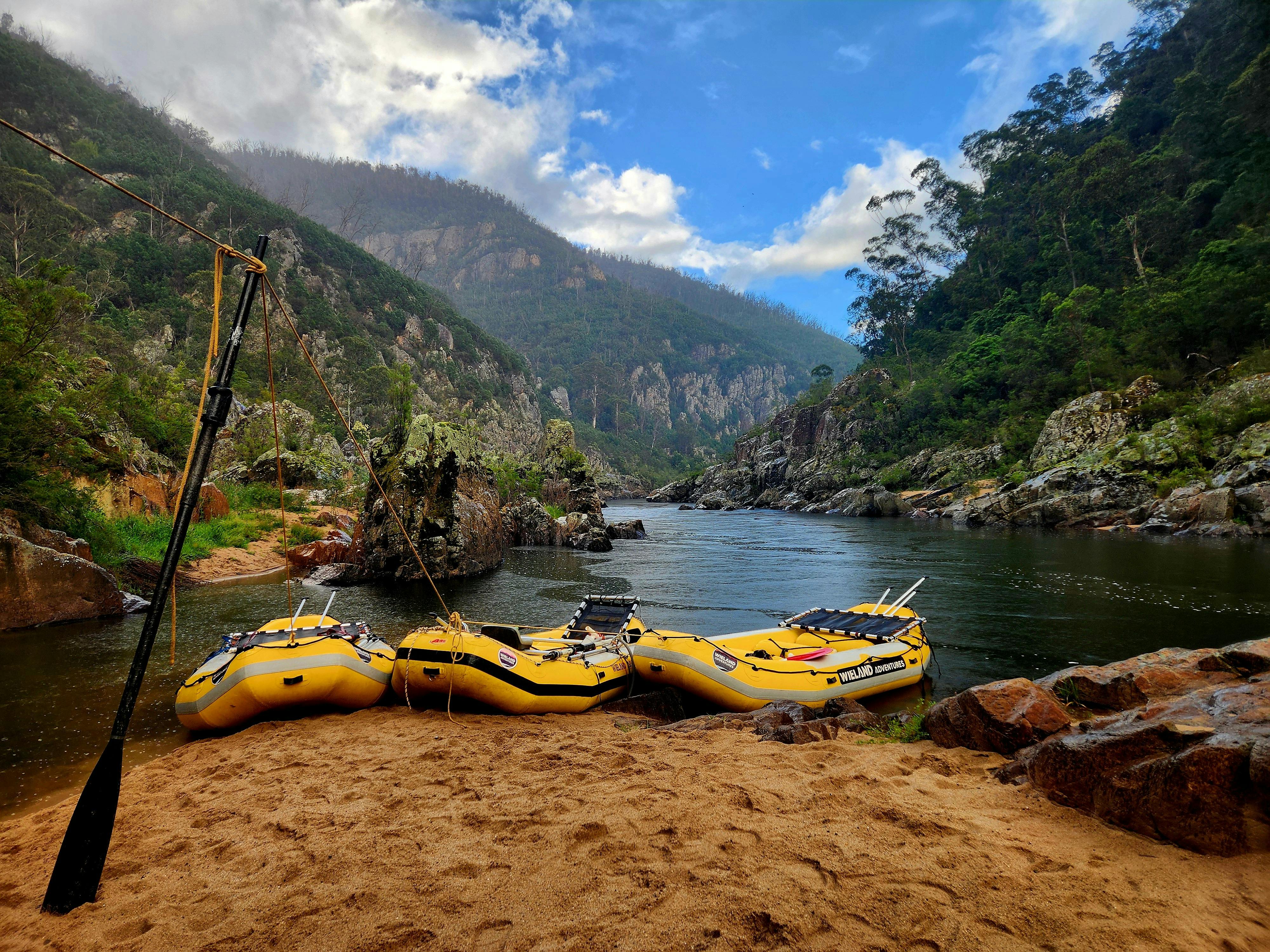 3 yellow rafts parked on a beach in a lovely location on the Snowy River in Tulloch Ard Gorge.