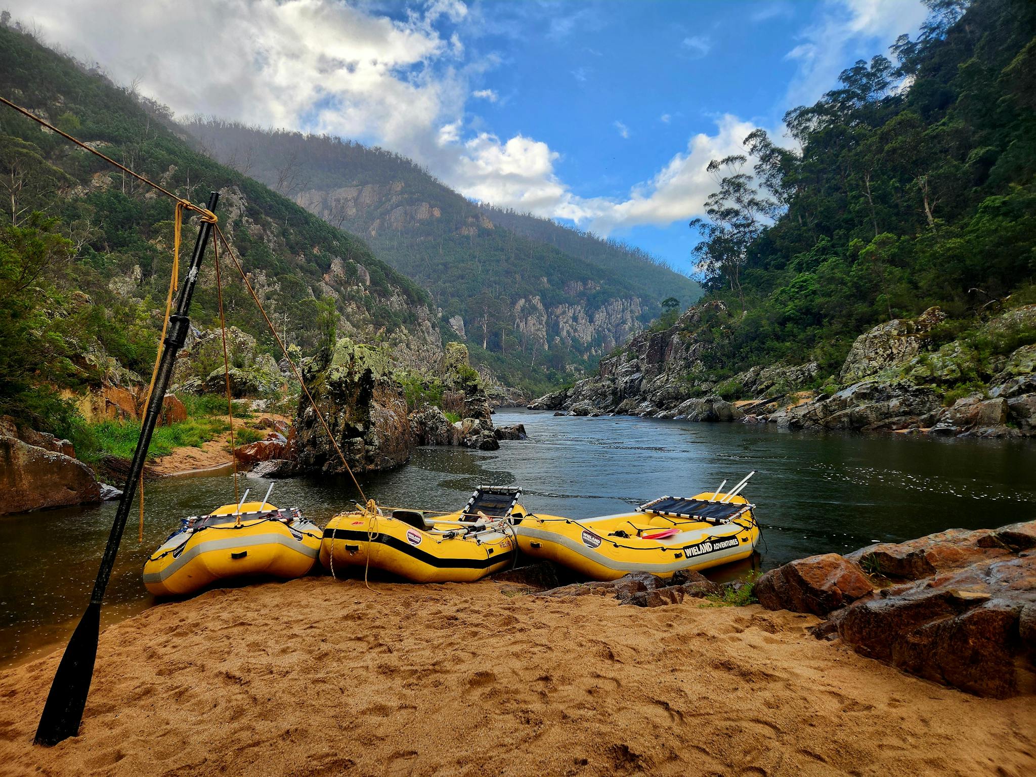 3 yellow rafts parked on a beach in a lovely location on the Snowy River in Tulloch Ard Gorge.