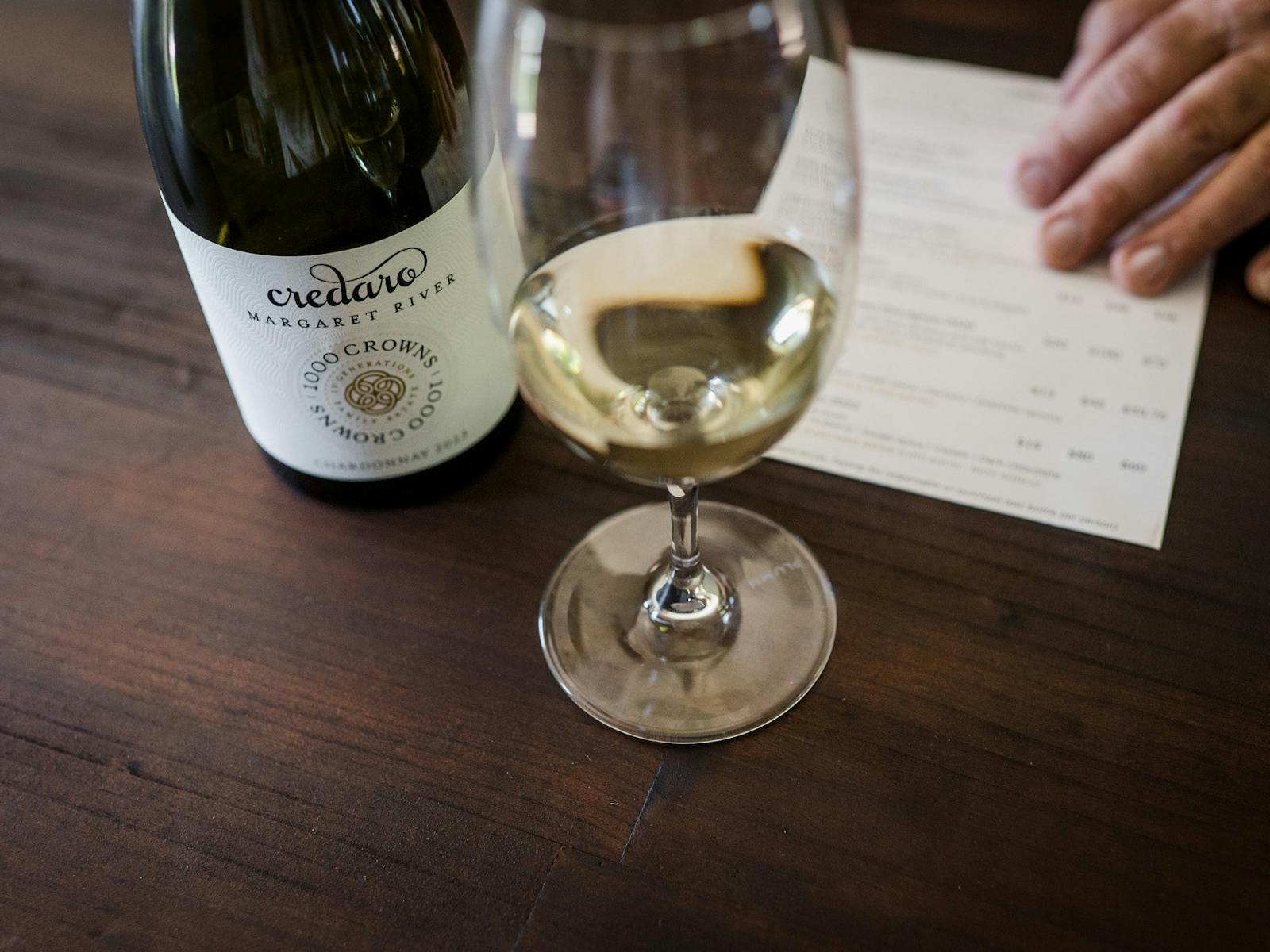 Credaro Estate 1000 Crowns Chardonnay bottle & wine glass with tasting menu in foreground