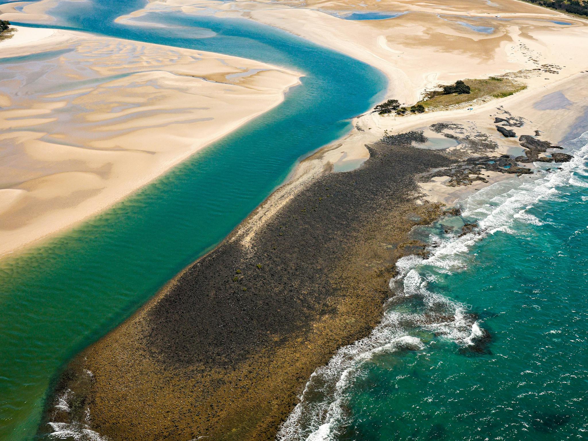 The headland between stunning green river and crystal sea The headland between stunning green river and crystal sea