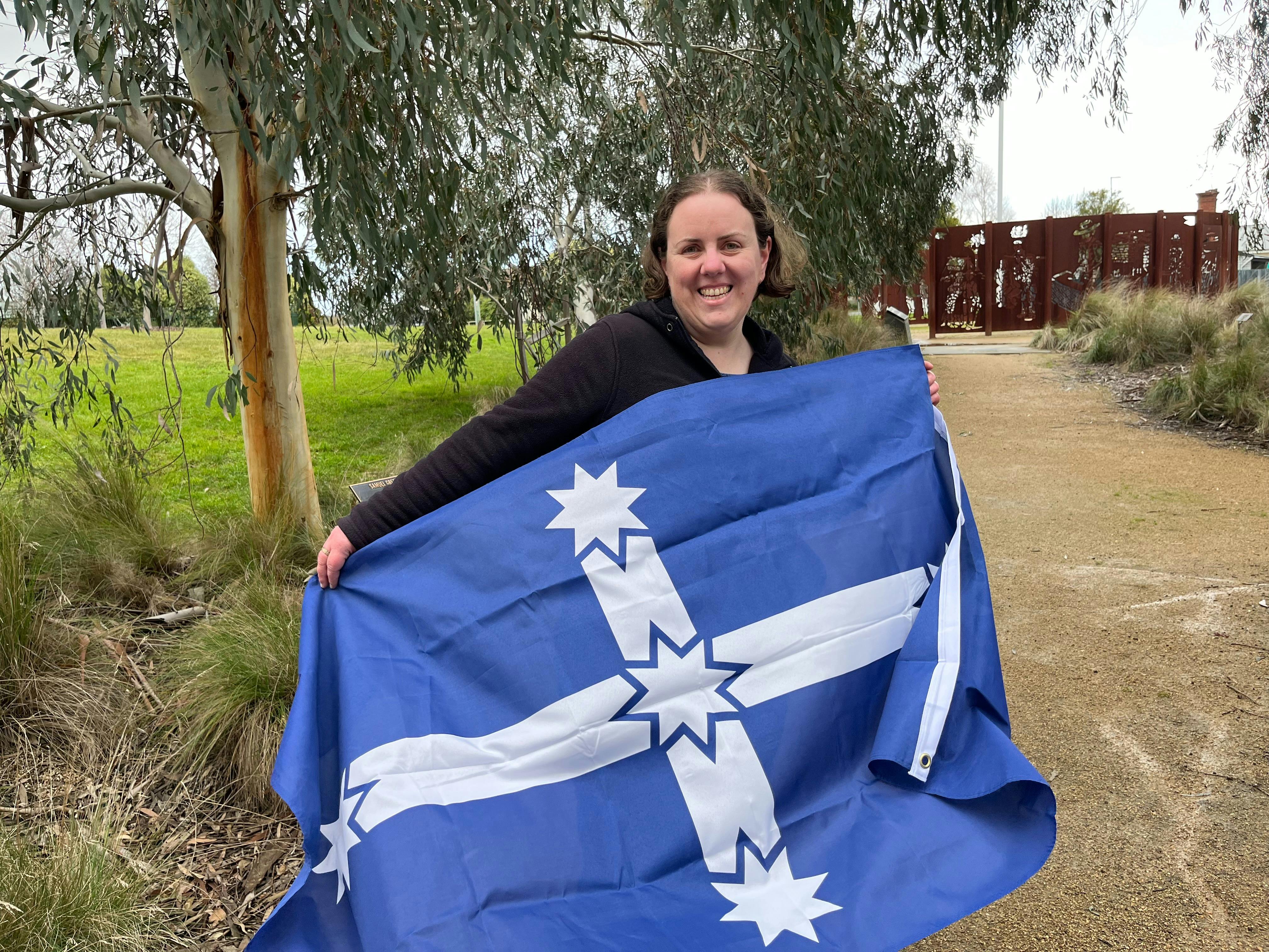 Lauren Powell holding the Eureka Flag in the Eureka Stockade Memorial Park