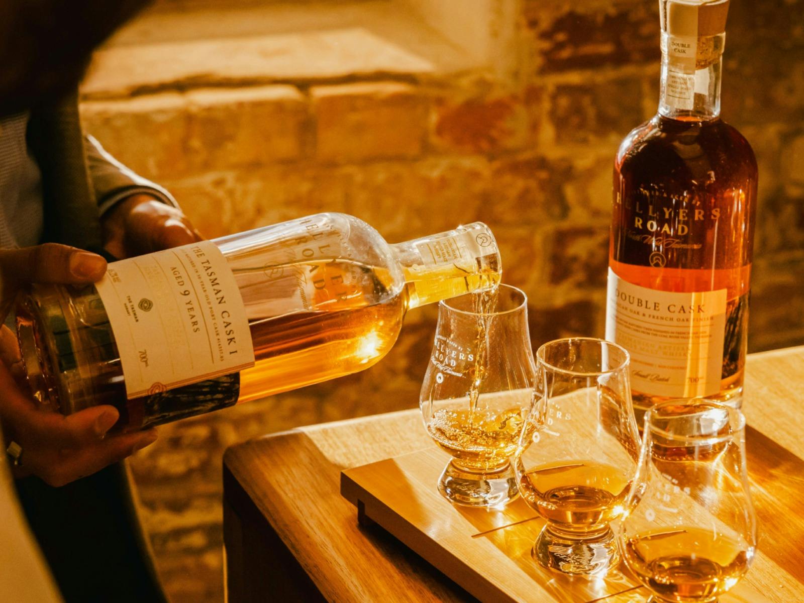Whiskies being poured into glencairns on a tasting board in the sandstone cellar