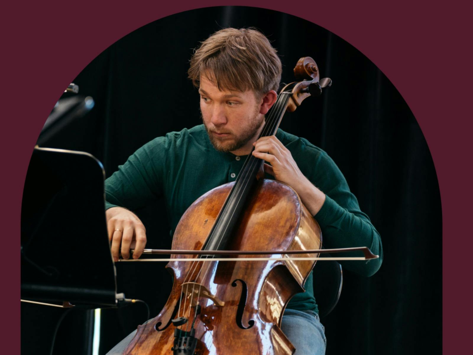 A musician playing the cello with a maroon background