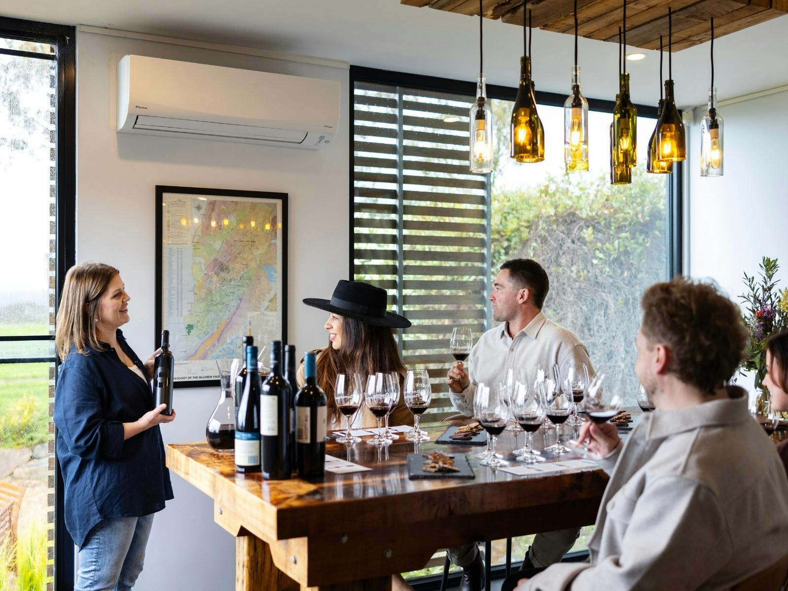 Group sitting at table for wine tasting experience at Gemtree Wines. Host talking about a bottle.