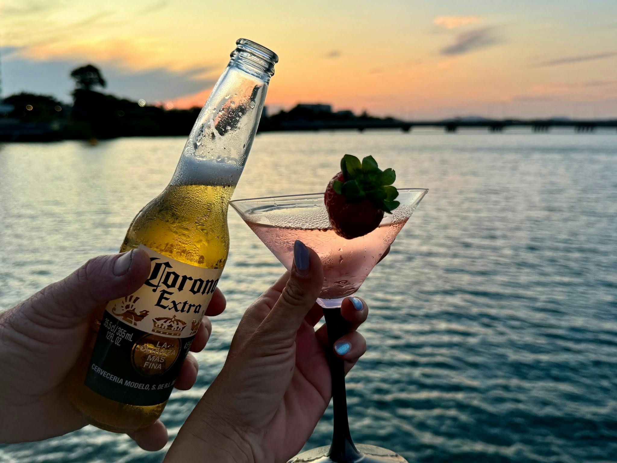 Cocktail glass with Corona bottle and sunset background Cocktail glass with Corona bottle and sunset background