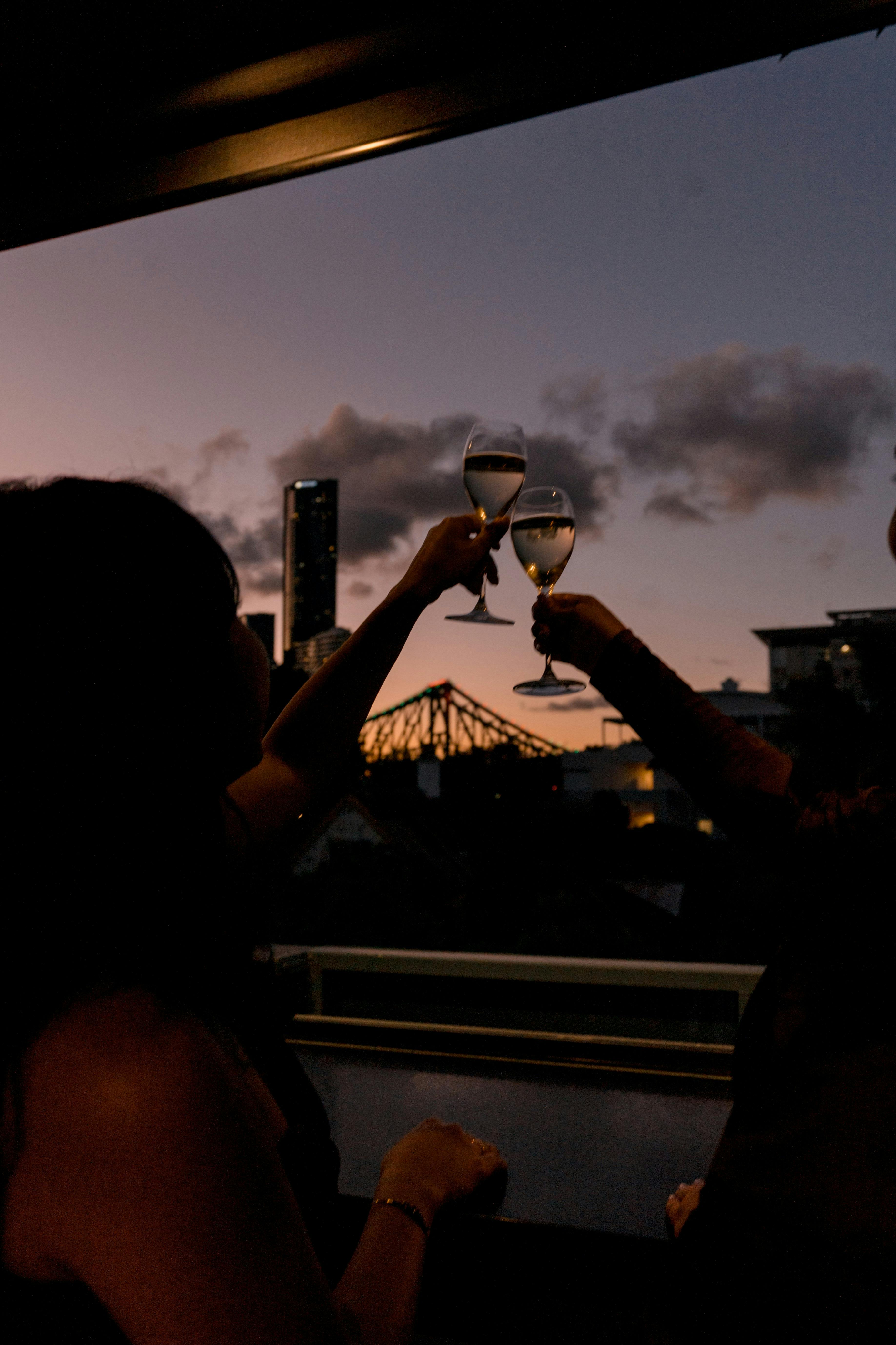 Cheers above sunset at rooftop bar